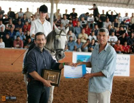 Click to Enlarge -  Mr. Micha Regev, Chairman of the Israel Arab Horse Society, presents the WAHO Trophy to Mr. Yftah Lev-Ron from Sabra Arabians.  Jupiter's rider at this special occasion is Noa Bergman